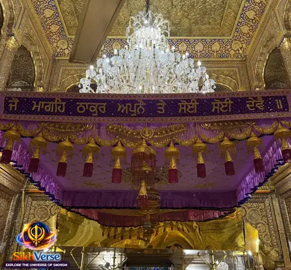 Punjabi Gurbani quote ‘Jo Mageh Thakur Apne Te Soi Soi Devai’ written on decorative palki inside Golden Temple Amritsar with chandelier and golden interior