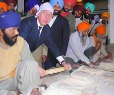 British Foreign Minister Jack Straw makes chapatis at the langar hall of Golden Temple